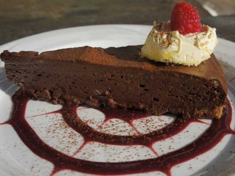 Rich chocolate mousse tart with raspberry coulis